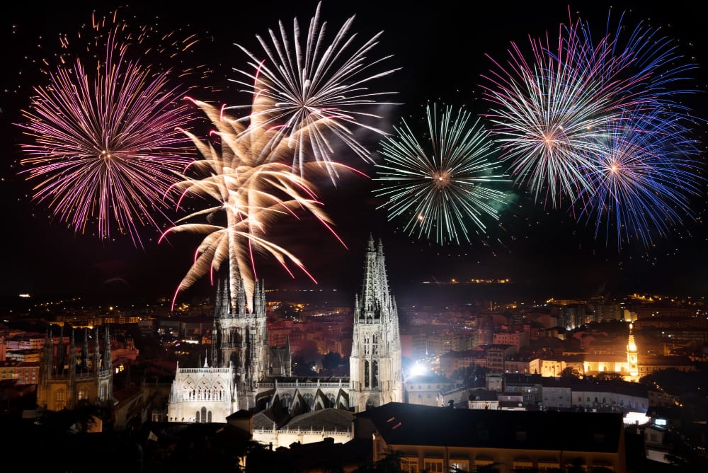 Silvester Gala mit Stil 1 Feuerwerk über einer beleuchteten gotischen Kathedrale in einer Stadt bei Nacht.